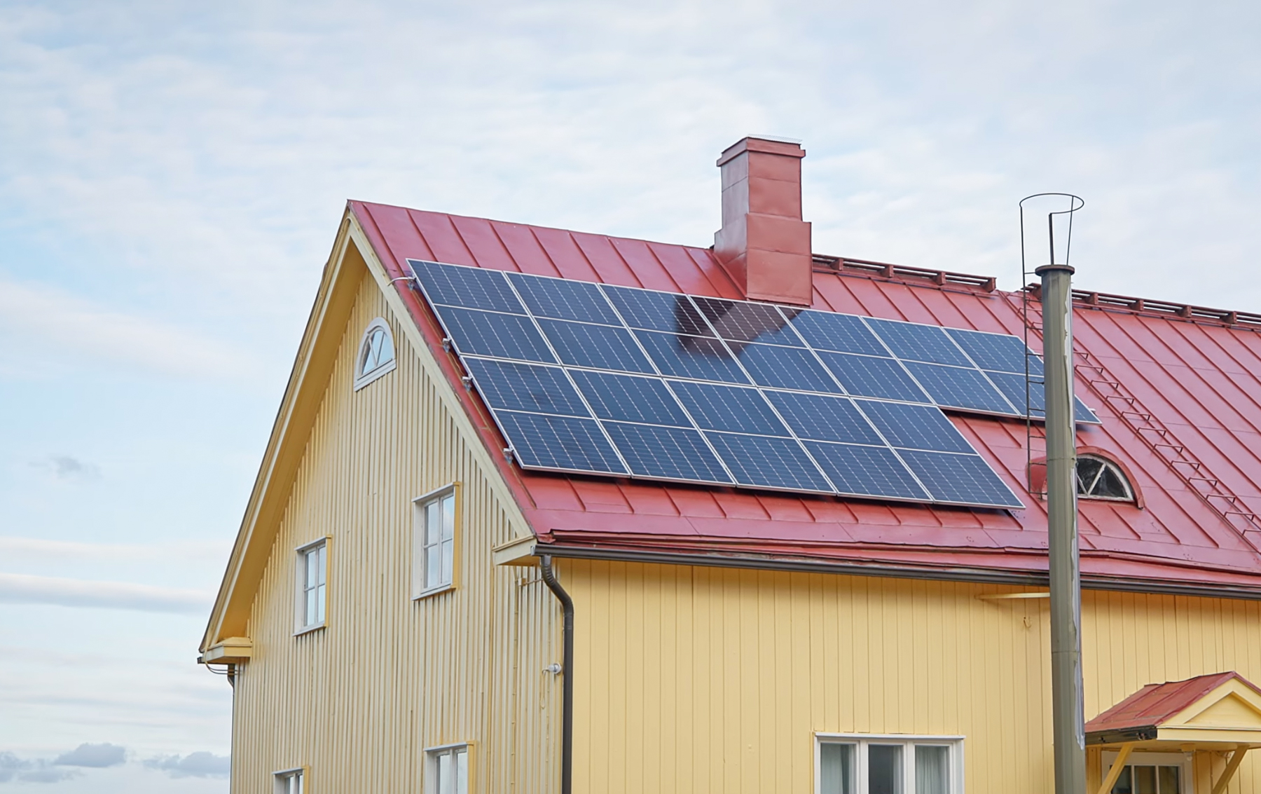 Kätkänjoen kylätalon aurinkopaneelit punaisella peltikatolla